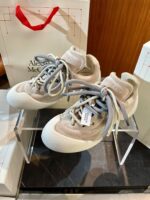Scarpe Alexander McQueen in suede beige, design elegante e modern, su supporto trasparente.