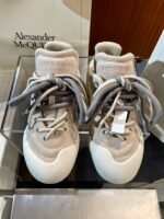 Sneaker di lusso Alexander McQueen in vetrina, design contemporaneo e dettagli sofisticati.