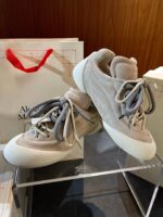 Sneakers di lusso beige e grigio con suola chunky, stile moderno e raffinato.