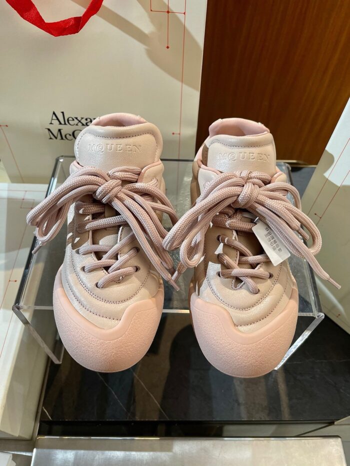 Sneakers rosa di lusso Alexander McQueen su esposizione elegante, stile moderno e sofisticato.