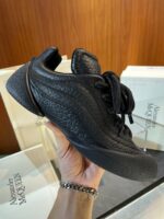 Sneaker nera di lusso Alexander McQueen, stile moderno, design elegante e dettagli premium.