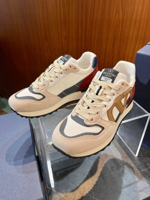 Sneakers in suede beige con dettagli blu e burgundy, scelti per stile e comfort raffinato.
