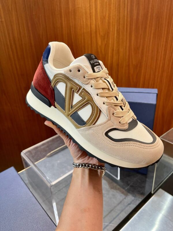 Sneaker di lusso con logo dorato, dettagli eleganti e design raffinato in beige e blu/navy.