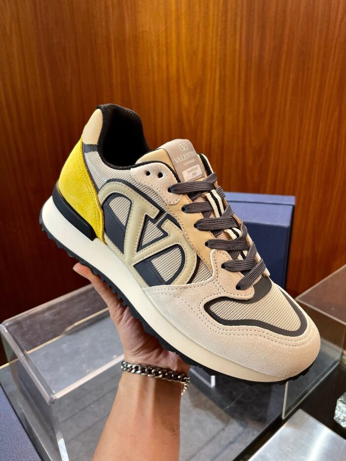 Sneaker moderna con logo a V, dettagli colorati e design elegante in mesh e suede.