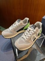 Sneakers sportive grigio, nero e verde in mostra, stile moderno e comfort casual.