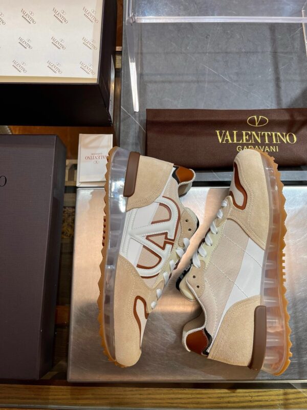 Sneakers di lusso Valentino in pelle e mesh su superficie in legno elegante.