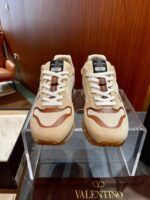 Sneakers Valentino casual di lusso con design elegante e dettagli raffinati su stand trasparente.