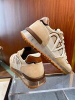 Sneaker da uomo beige e marrone con logo distintivo e suola trasparente in stile moderno.