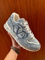 Sneaker in denim blu con logo bianco, suola trasparente e stile casual trendy.