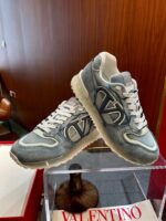 Sneakers di lusso moderne con logo contrasto su pedana, sfondo in legno elegante, stile casual chic.