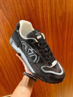 Sneaker moderna in nero con dettagli bianchi e comfort elevato su sfondo in legno caldo