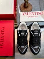 Sneakers Valentino Garavani di lusso su tavolo con packaging elegante e design moderno.