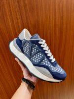 Sneaker moderna blu navy con dettagli geometrici, su sfondo in legno caldo.