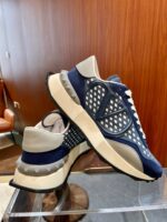 Sneakers moderne navy e crema con suola chunky su sfondo legno elegante.
