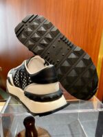 Sneaker moderna nero e bianco con suola robusta, design elegante e stile sportivo.