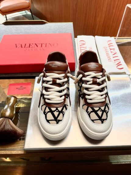 Sneakers Valentino di lusso su superficie elegante con accessori di moda e sfondo raffinato.