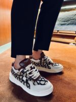 Sneakers bianche moderne con dettagli in pelle e design stile streetwear elegante.