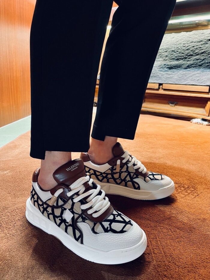 Sneakers bianche moderne con dettagli in pelle e design stile streetwear elegante.