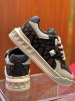 Sneakers nere e bianche trendy con dettagli in pelle e allacciatura moderna, ideali per ogni occasione.