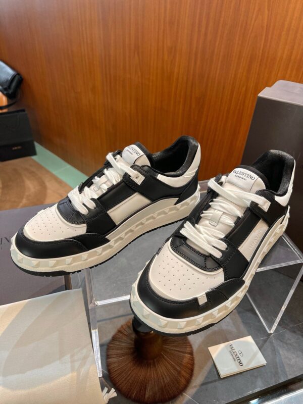 Sneakers di design moderno con suola spessa e dettagli eleganti in black e crema.