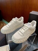 Sneakers minimaliste in bianco crema con suola spessa, design elegante e stile urbano moderno.