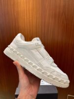 Sneaker moderna in pelle crema con sistema di lacci innovativo e suola spessa elegante.
