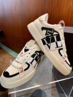 Sneakers eleganti con grafiche VI su sfondo in legno, stile moderno e trendy.