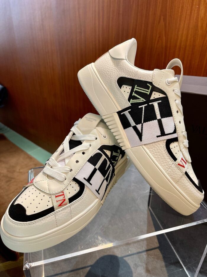 Sneakers eleganti con grafiche VI su sfondo in legno, stile moderno e trendy.