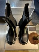 Stivaletti neri moderni con bordo elastico e spazzola per cura calzature eleganti e pratici.