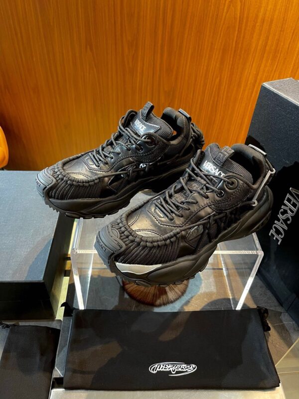 Sneakers nere chunky di design moderno, in esposizione su piedistallo premium.