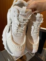 Sneakers Versace di lusso, stile streetwear con dettagli ruffle e logo visibile.