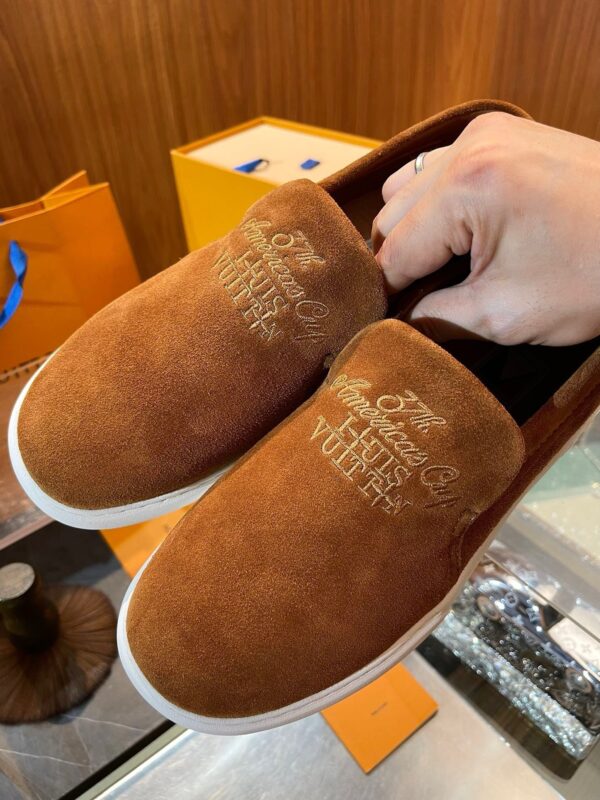 Scarpe slip-on in suede con dettagli in oro, stile elegante e sofisticato, perfette per ogni occasione.