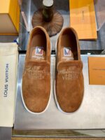 Scarpe slip-on in suede Louis Vuitton con ricamo branding, accessori di lusso in boutique raffinata.