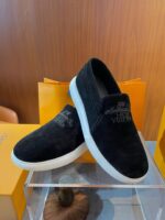 Scarpe slip-on nere in suede con suole bianche, stile moderno e versatile per ogni occasione.