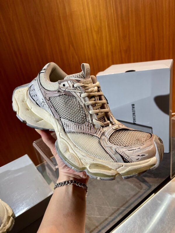Scarpa sneakers moderna beige con mesh, suola spessa e look vintage, foto su sfondo di legno.
