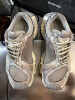 Sneakers eleganti in grigio con suola spessa e dettagli di design moderni.