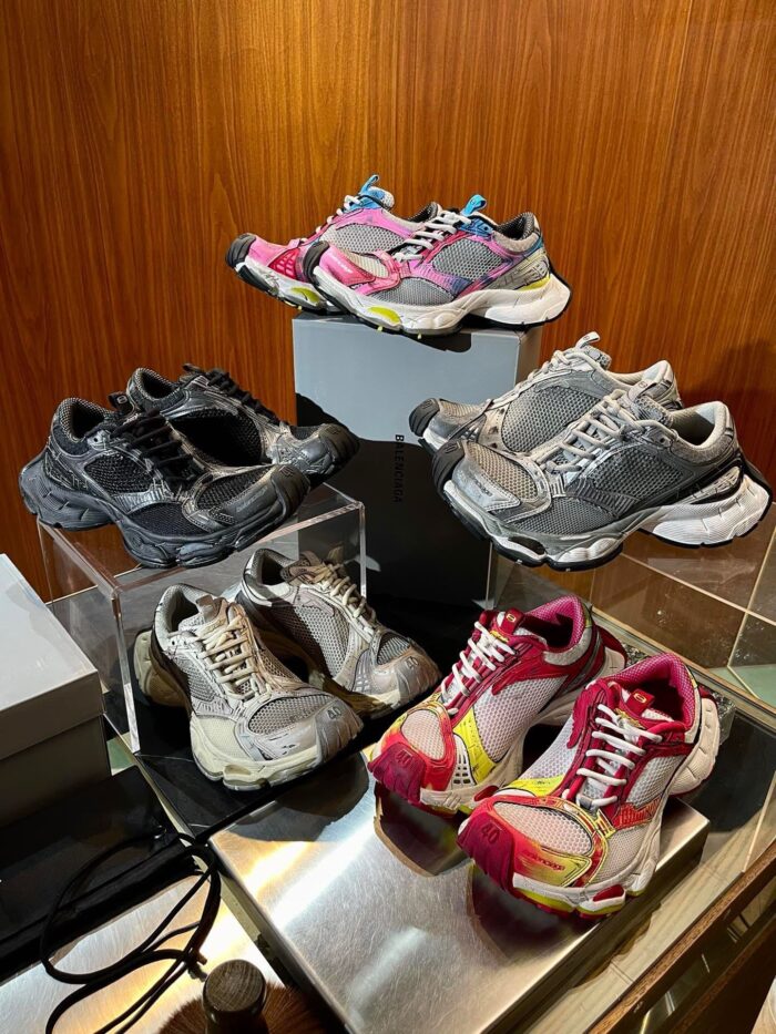 Collezione di sneakers vintage in interno con dettagli in legno e luci soffuse.