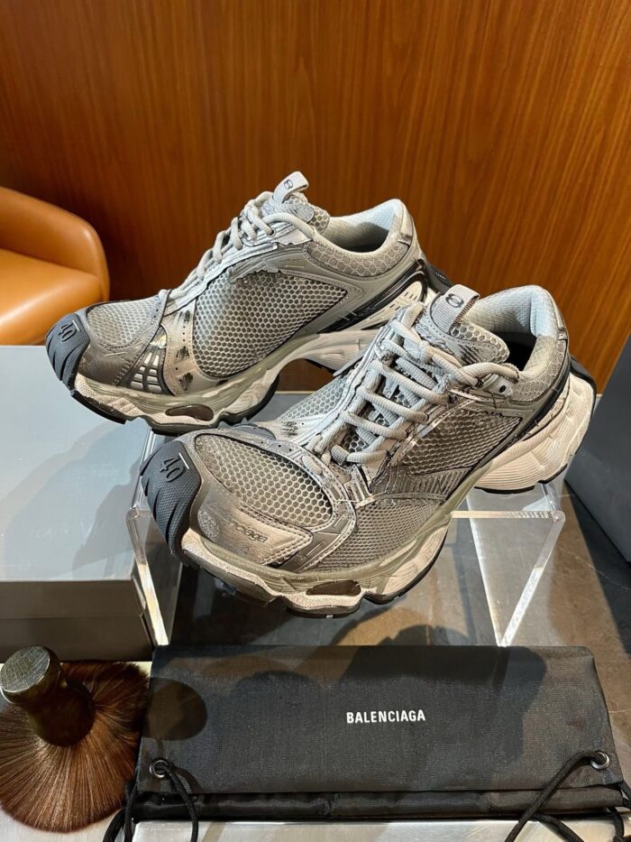 Sneakers Balenciaga di lusso su supporto trasparente in ambiente elegante e moderno.
