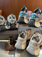 Collezione di sneakers usati con spazzola per la cura su superficie elegante in ambientazione calda.
