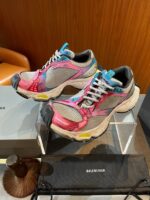 Sneakers moderne colorate con tomaia in mesh e suola supportiva, su stand elegante e di tendenza.