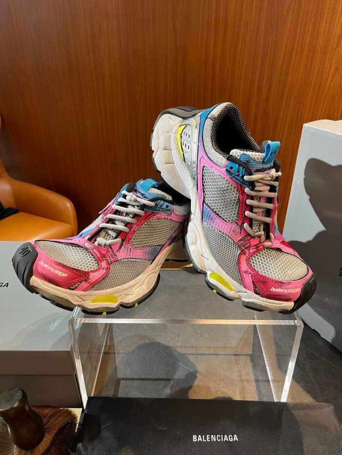 Scarpe sportive colorate su pedana elegante, design moderno e look vivace per fitness e casual.