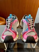 Scarpe sportive colorate con dettagli vivaci su fondo in legno, stile dinamico e versatile.