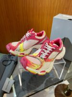 Sneakers colorate moderne su supporto in plexiglass con dettagli vibranti e design innovativo.