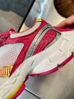 Sneaker sportiva moderna con dettagli rosa, riflettenti e suola antiscivolo per alte prestazioni.