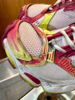Scarpe da corsa moderne con design rosa, giallo e mesh traspirante ad alte prestazioni.