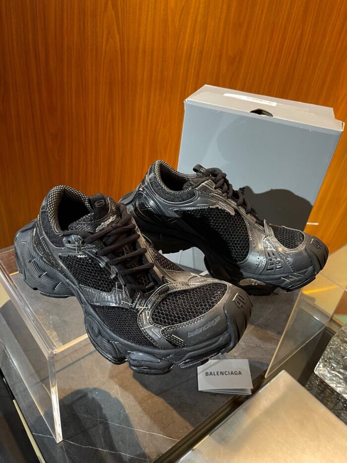 Sneakers moderne di design su pedana di vetro, stile elegante, dettagli innovativi e materiali di qualità.