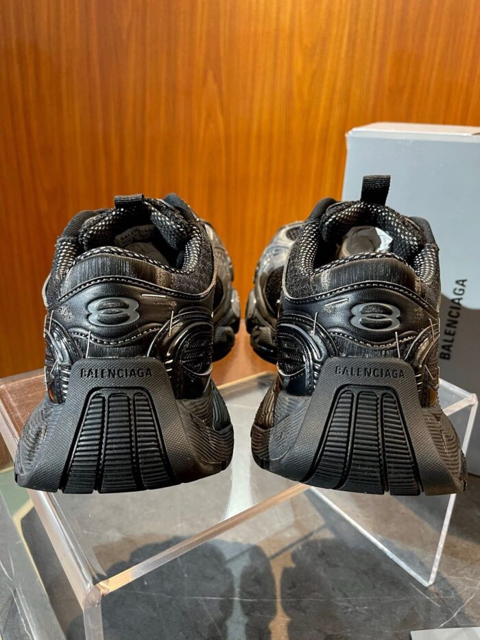 Sneakers Balenciaga nere con design innovativo, su supporto in vetro, stile moderno e di lusso.