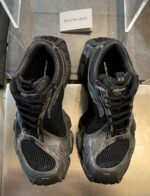 Sneaker Balenciaga nere in showroom moderno, stile sportivo di lusso con design contemporaneo.