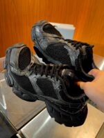 Scarpe sportive nere con dettagli grigi e suola robusta, ideali per casual e performance.