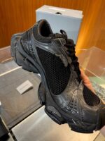 Sneaker nero sportivo con dettagli riflettenti, design moderno e comfort elevato per attività fisica.